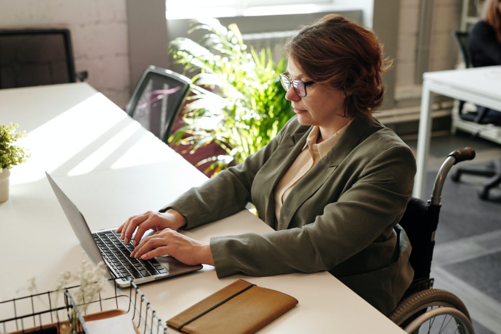 Obrazek przedstawia kobietę korzystającą z laptopa