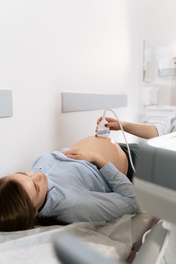 Obrazek przedstawia kobietę w ciąży podczas badania USG